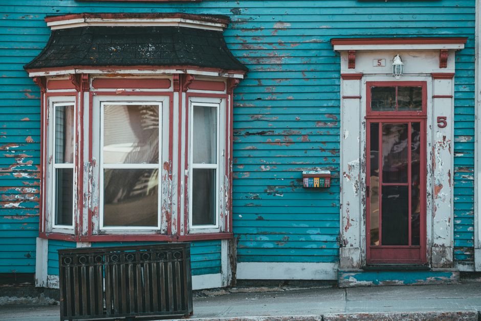 Blue painted house wall with a bay window