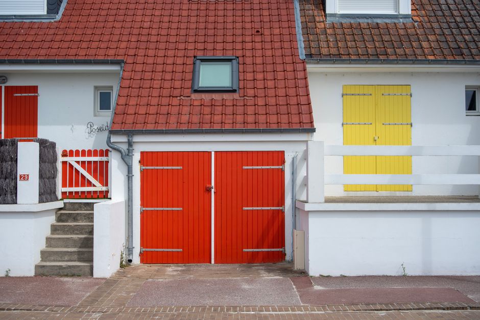 Painted house front with red and yellow doors