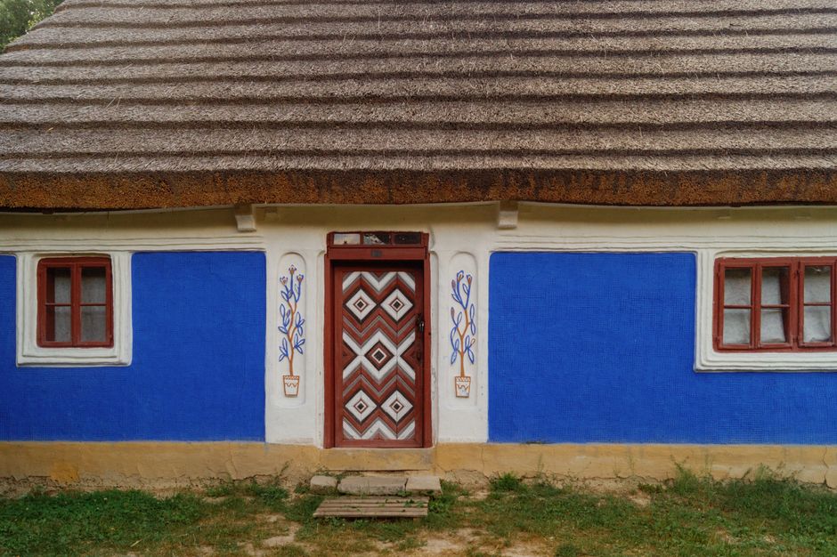 Blue painted wall under a thatched roof